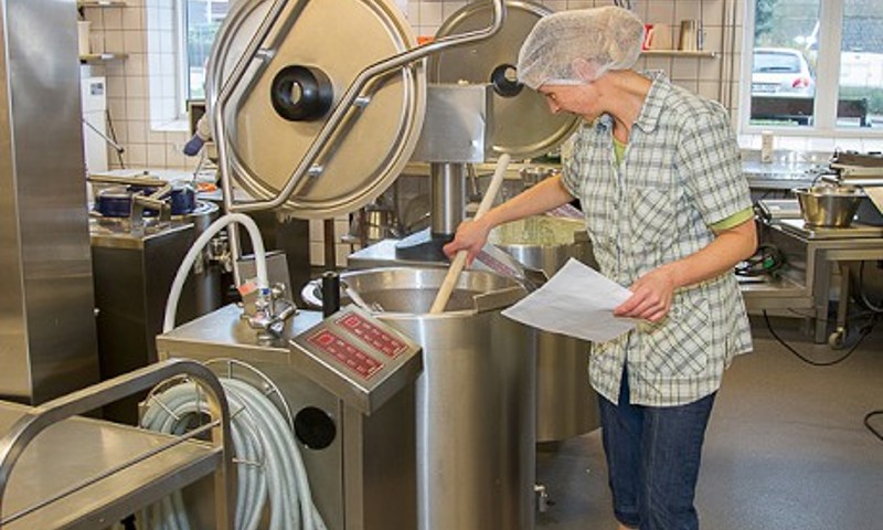 Kvinde rører i en stor gryde Kvinde rører i en stor gryde